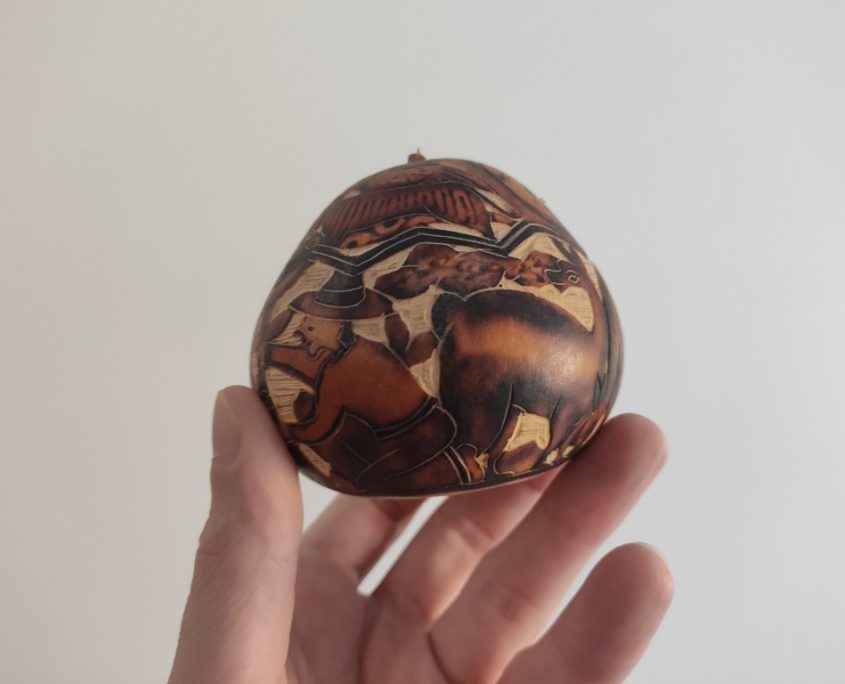 An intricately carved and painted calabash fruit from Bolivia